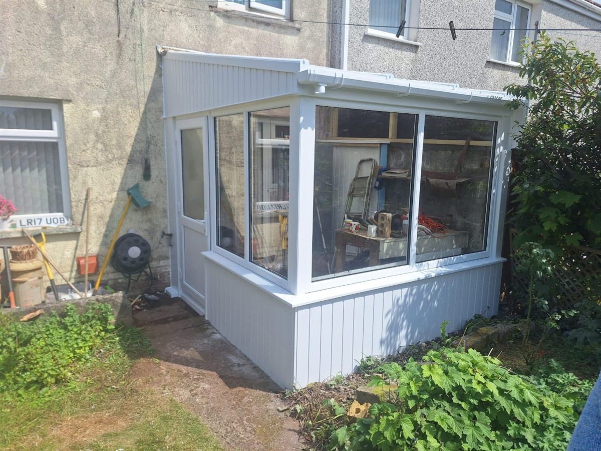 New white uPVC porch with a glazed upper section on two sides, insulated Hollowclad dwarf walls and a matching uPVC door