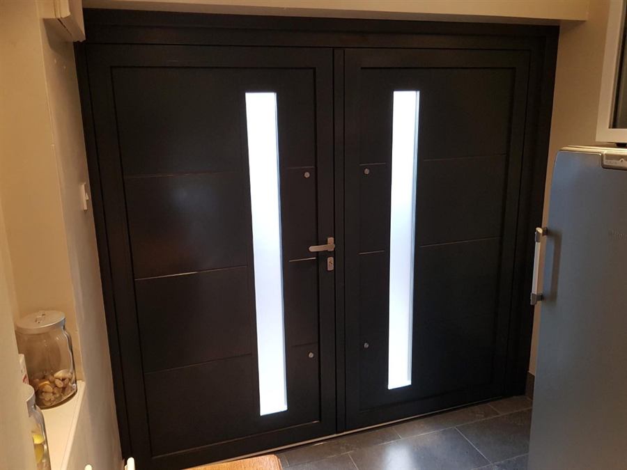 Black double doors with slim full-height obscure glass panels, seen from inside