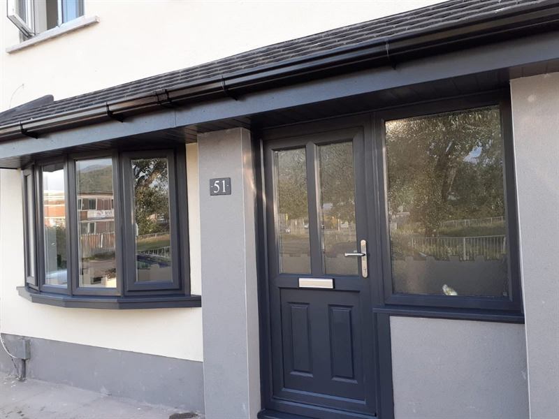 Anthracite grey composite front door and glazed side panel beside a matching anthracite bay window, Port Talbot